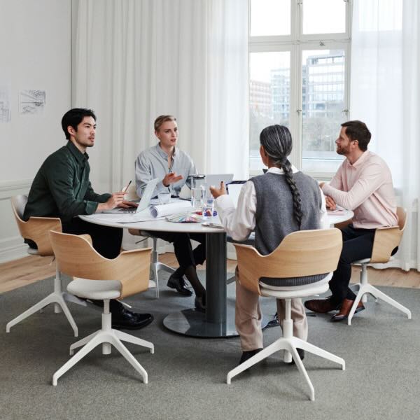 Foto von vier Menschen, die an einem Konferenztisch sitzen