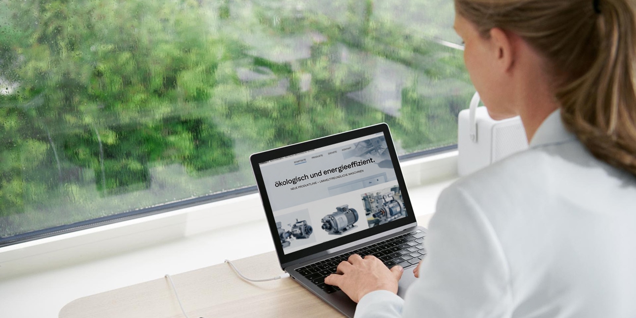 Foto von einer Frau an einem Laptop in Rückenansicht.
