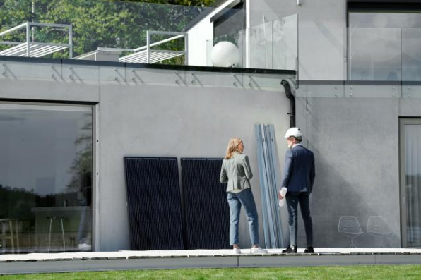 Eine Frau und ein Mann stehen vor einem Haus