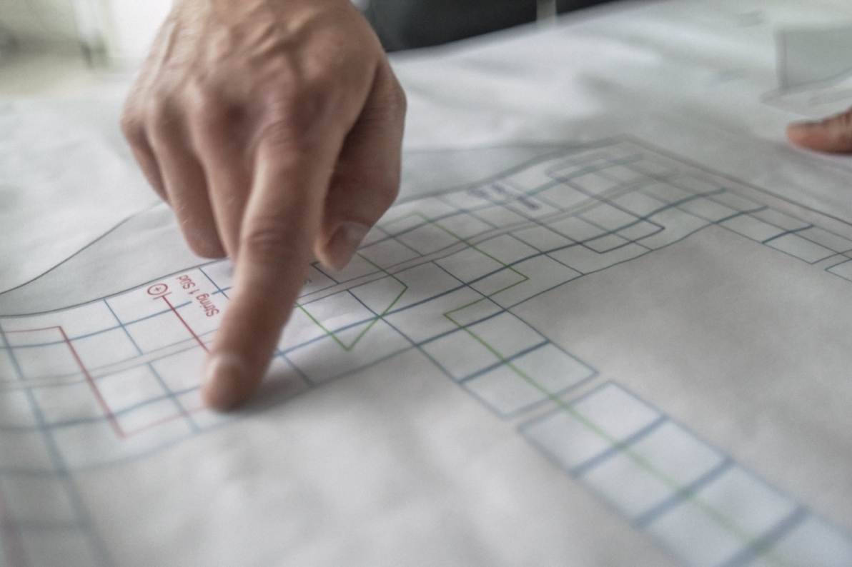 Hand zeigt auf technischen Bauplan eines Energieprojekts.