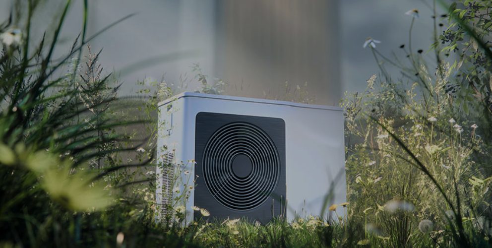 Moderne Wärmepumpe steht auf einer Wiese umringt von vielen verschiedenen Blumen und Gräsern.