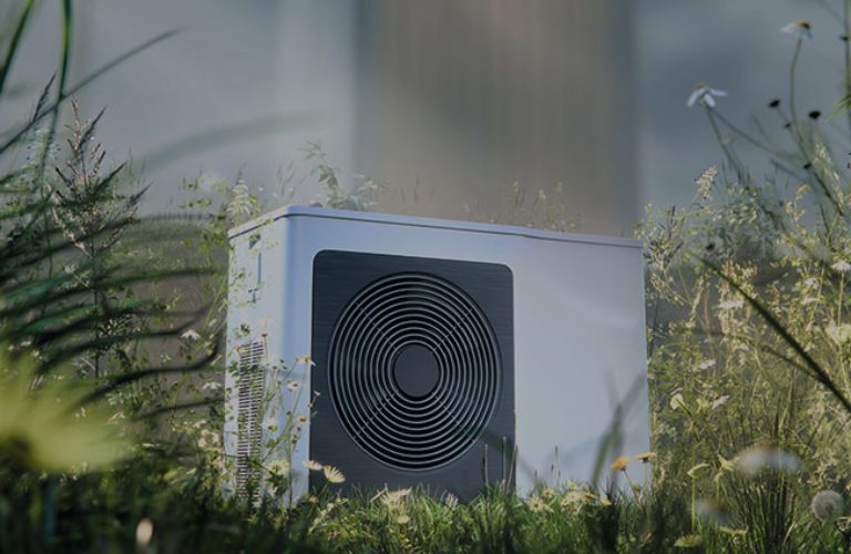 Moderne Wärmepumpe steht auf einer Wiese umringt von vielen verschiedenen Blumen und Gräsern.