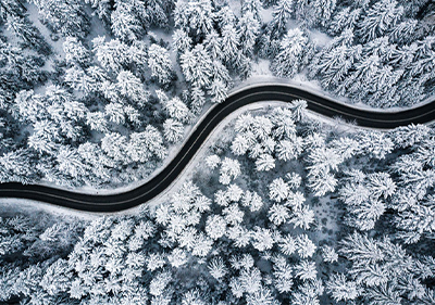 Vogelperspektive Landstraße im Wald im Winter