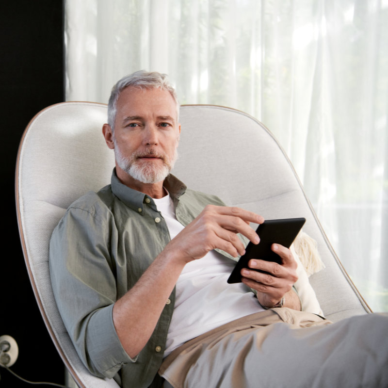 Smart Metering Mann relaxt im Sessel mit Tablet