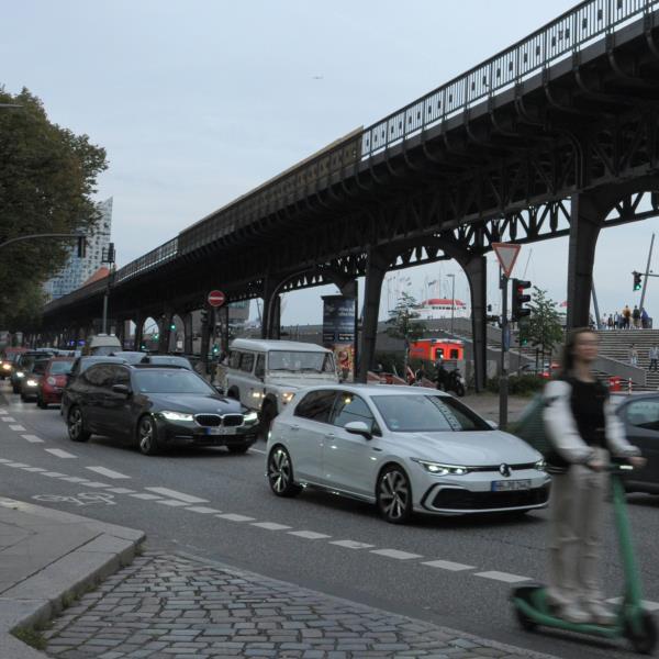 Remote Work - Menschen auf dem Weg zur Arbeit an den Landungsbrücken in Hamburg, Autos stehen im Stau