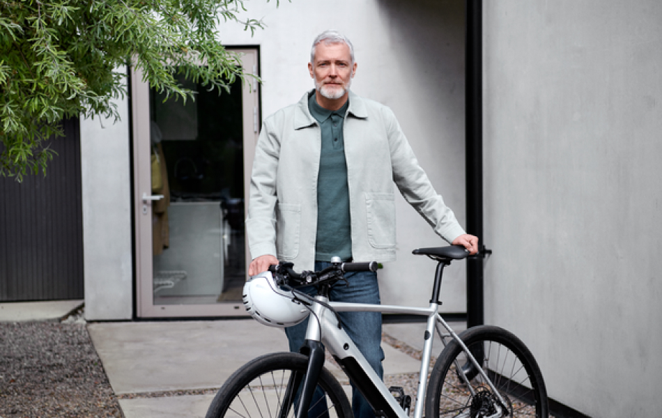 Tipps Energiesparen: Älterer Mann mit E-Bike in einem Hauseingang