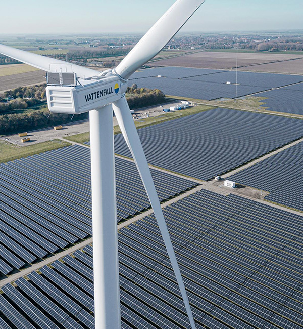 Windkraftrad vor Solaranlagen