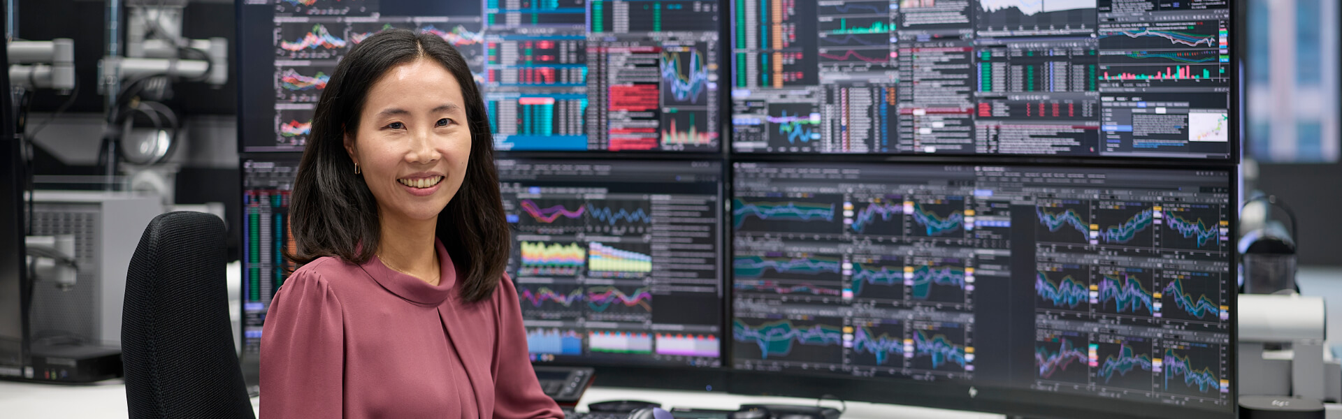 Frau vor mehreren Bildschirmen