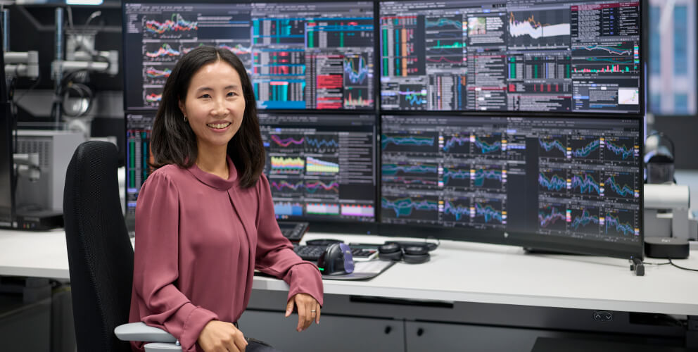 Frau vor mehreren Bildschirmen