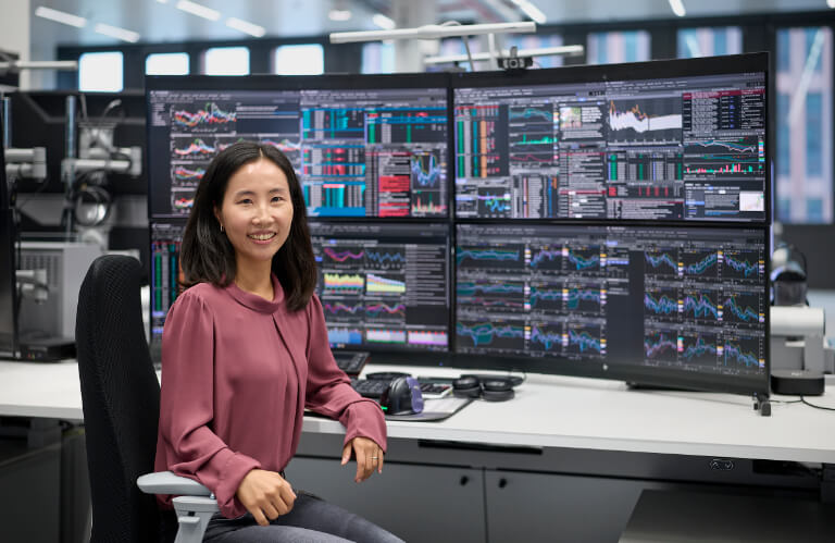 Frau vor mehreren Bildschirmen