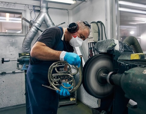 Mann baut ein Blasinstrument in einer Werkstatt