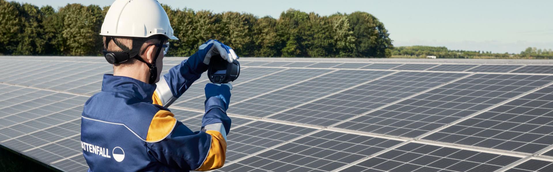 Vattenfall Mitarbeiter hält Messgerät vor Solarpark