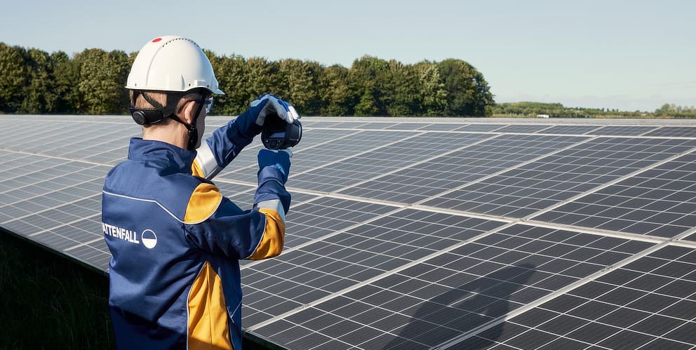 Vattenfall Mitarbeiter hält Messgerät vor Solarpark