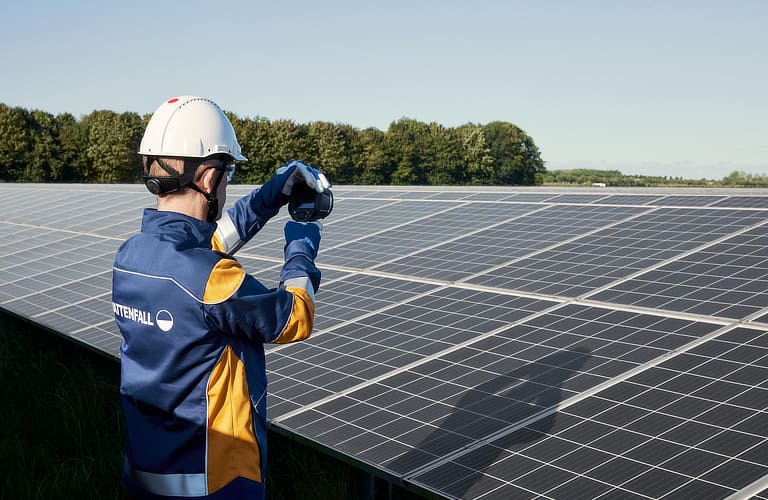 Vattenfall Mitarbeiter hält Messgerät vor Solarpark