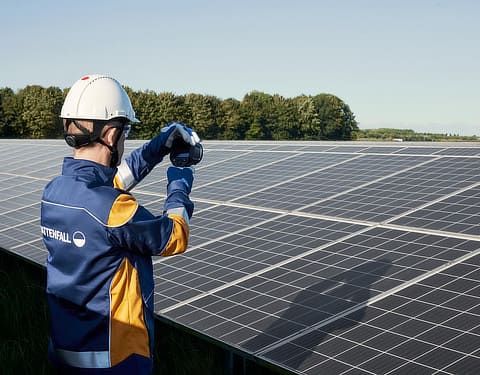 Vattenfall Mitarbeiter hält Messgerät vor Solarpark