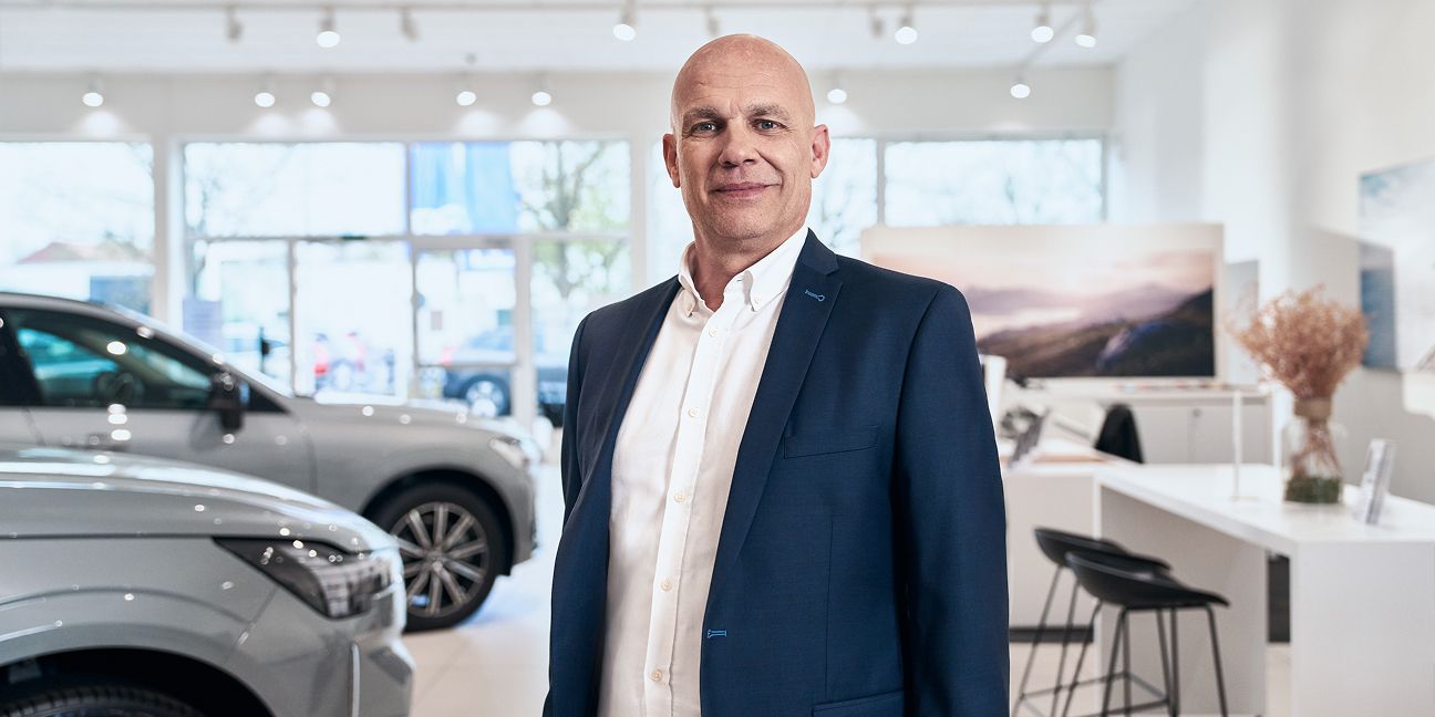 Das Bild zeigt Kay-Uwe Braasch, den Geschäftsführer des Volvo B&E Autohauses im Verkaufsraum der FIliale
