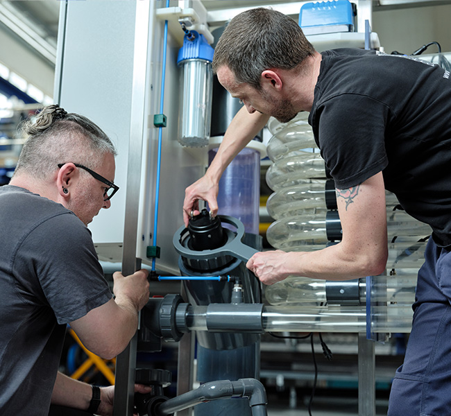 Dieses Foto zeigt Techniker an einer Anlagen von Algenwerk