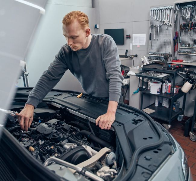 Dieses Bild zeigt einen Arbeiter an einer Motorhaube und verdeutlicht das Thema Interview mit Kay-Uwe Braasch, Geschäftsführer von B&E Automobile