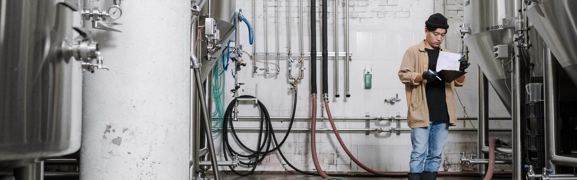 Mann steht in Brauerei.
