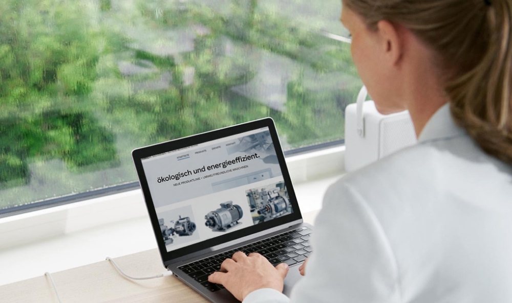 Ein Foto von einer Frau, die an einem Laptop sitzt, in Rückenansicht,