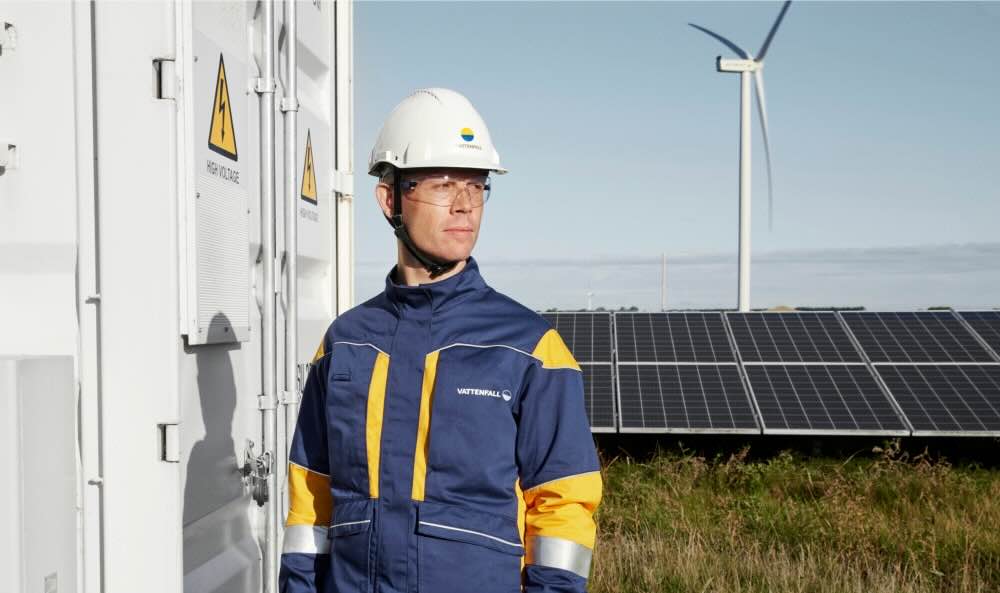 Ein Foto von einem Mann vor einer Solaranlage und einem Windrad