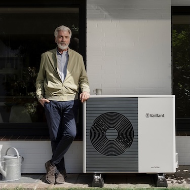 Mann steht neben einer Wärmepumpe