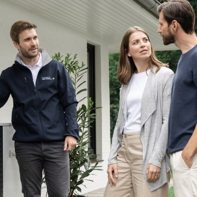 Wärmepumpe vor einem Haus mit verschneitem Dach