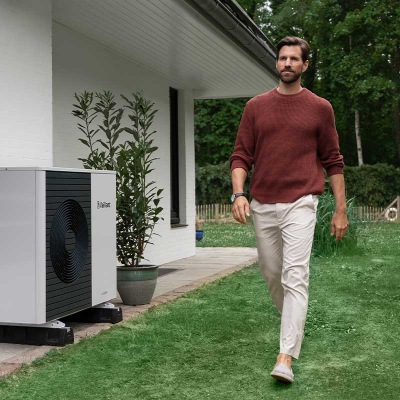 Wärmepumpe vor einem Haus mit verschneitem Dach