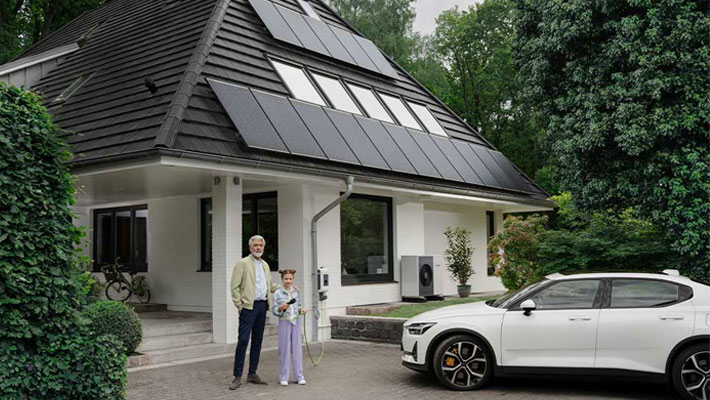 Opa mit Enkelkind vor Haus mit Solaranalge