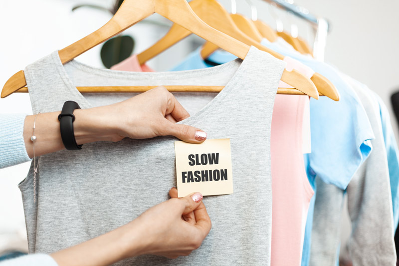 T-Shirt mit Slow Fashion Sticker auf Kleiderbügel