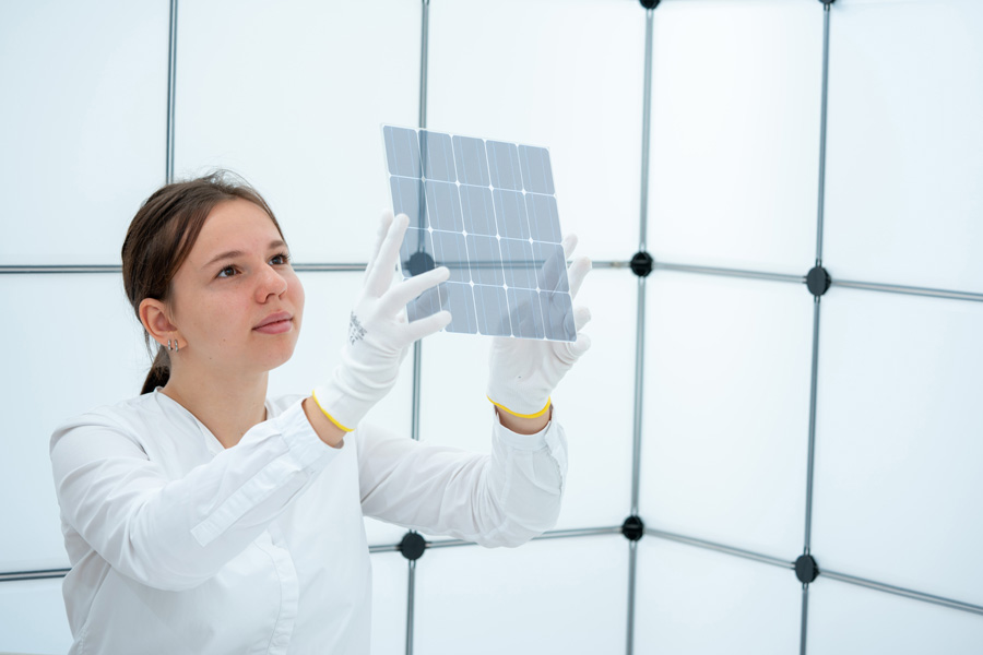 Frau hält Teile des Solarmoduls