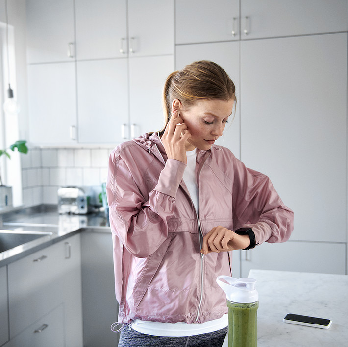 Frau schaut auf die Smart Watch