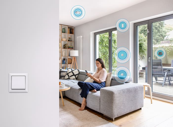 Frau bedient Smart Home App im Wohnzimmer