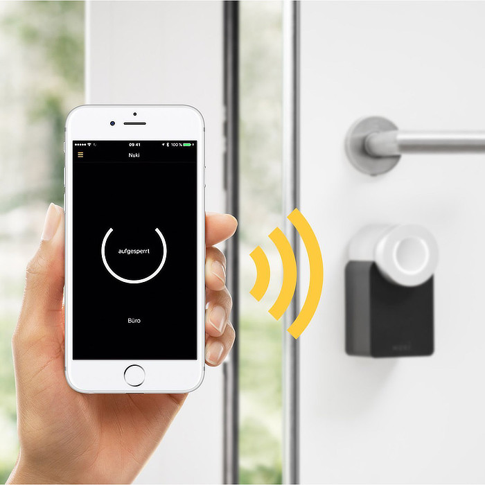 Hand hält Smartphone mit smart Lock App