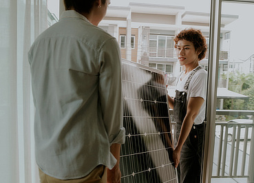 Zwei Personen tragen Solarpaneel