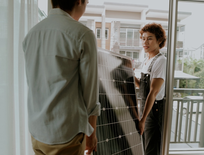 Zwei Personen tragen Solarpaneel