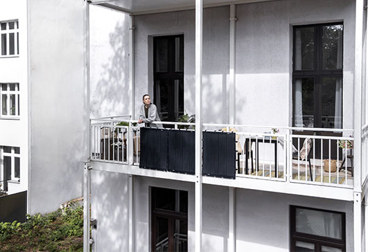 Frau steht auf einem Balkon mit Balkonkraftwerk