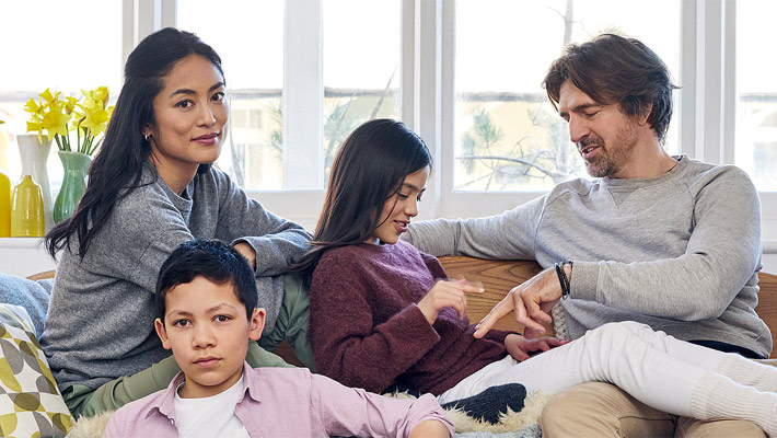 Familie sitzt auf einem Sofa