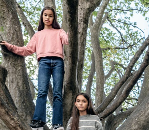 Zwei Mädchen klettern einen Baum