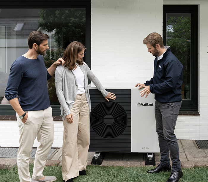 Ein Energieberater bereit ein Paar vor ihrem Haus zu Wärmepumpen