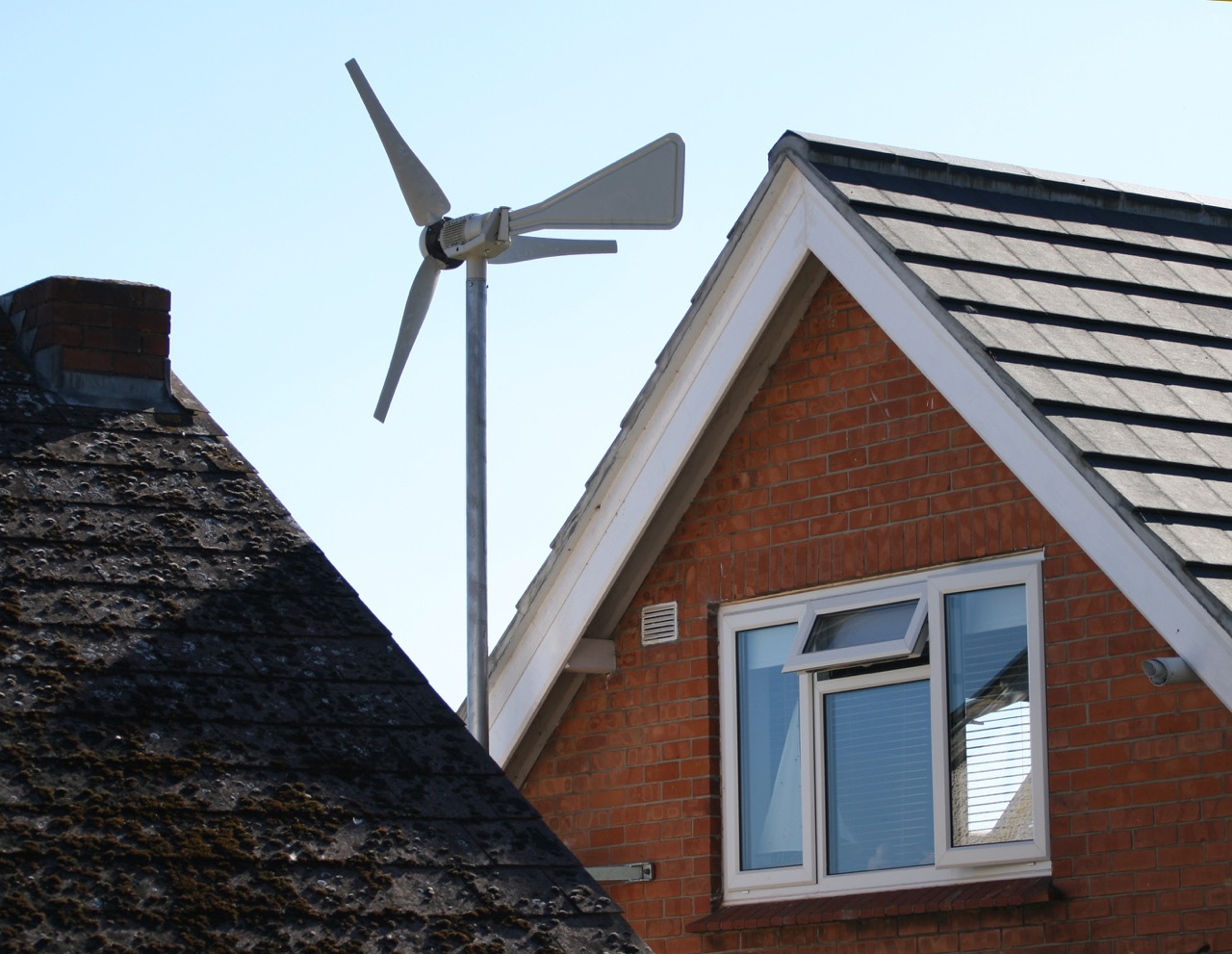 Kleines Windrad zwischen zwei Häusern zur Energieerzeugung in einem Wohngebiet