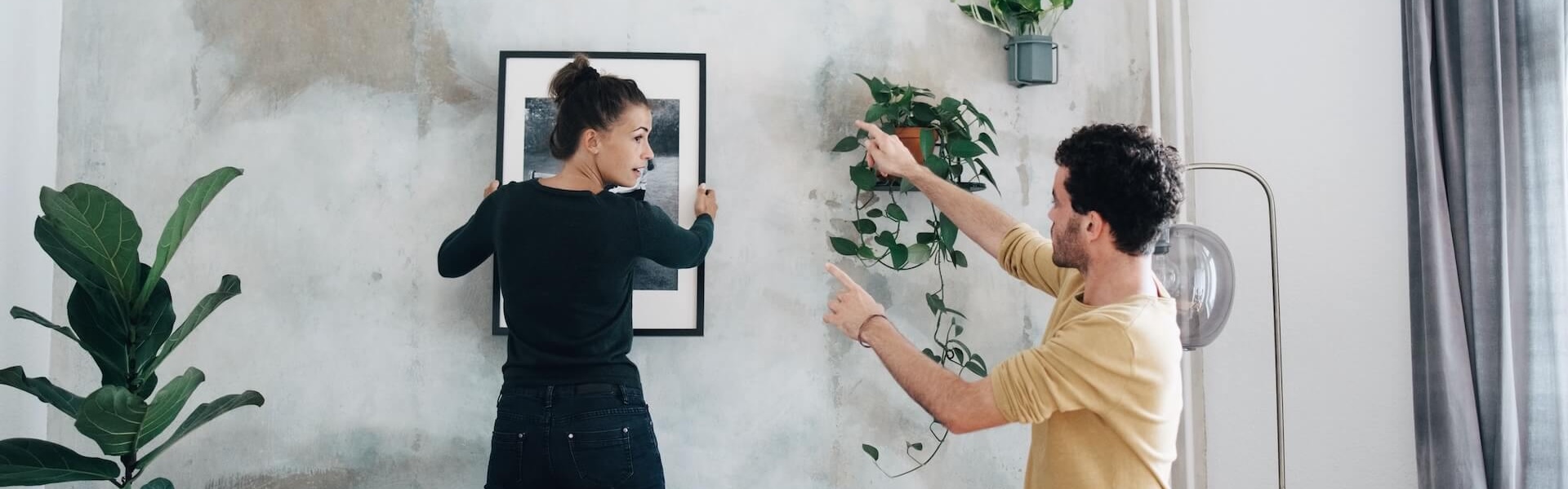 Frau und Mann bringen ein Bild an  die Wand