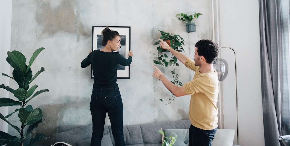 Frau und Mann bringen ein Bild an  die Wand