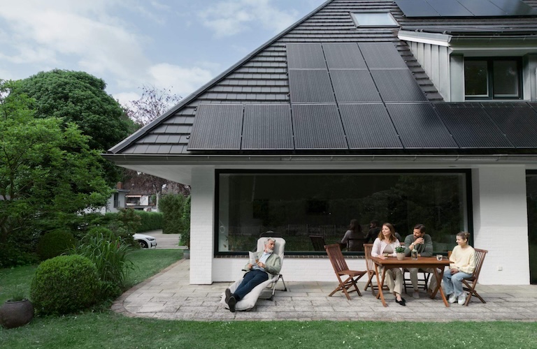Familie vor Haus mit Solarpanelen