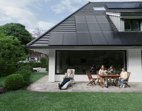 Familie vor Haus mit Solarpanelen