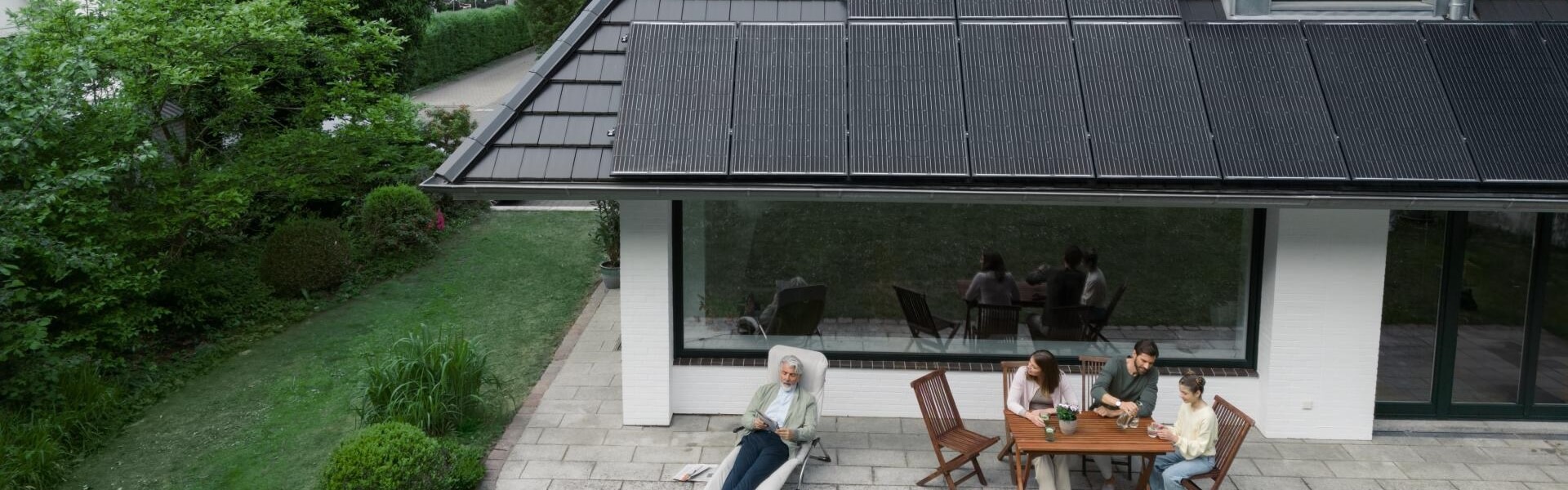 Familie vor Haus mit Solarpanelen
