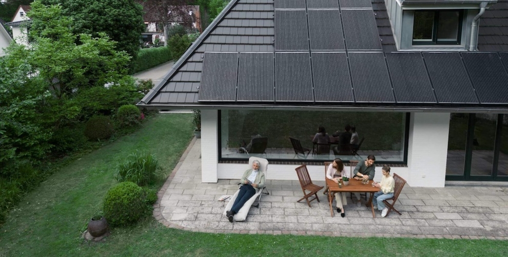 Familie vor Haus mit Solarpanelen