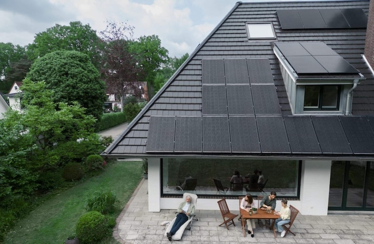 Familie vor Haus mit Solarpanelen