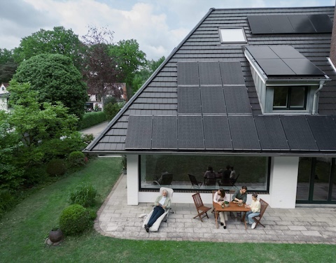 Familie vor Haus mit Solarpanelen