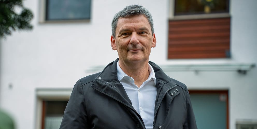 Vattenfall PV-Kunde steht von seinem Haus und schaut in die Kamera